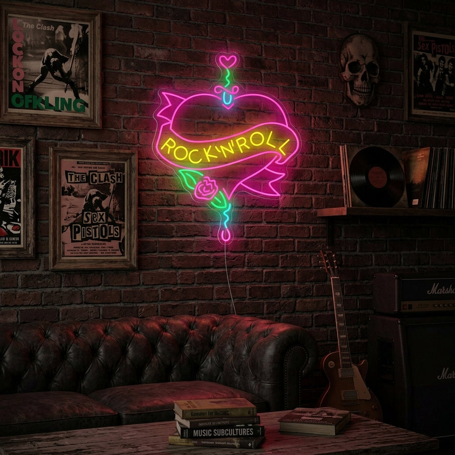 A close-up photograph capturing the glowing 'Rock N Roll' neon sign illuminating a cozy, wood-paneled room. The sign features stylized red text 'ROCK' and electric blue 'ROLL' with lightning bolt accents, reflecting slightly on nearby vinyl records and a worn guitar resting on a stand.