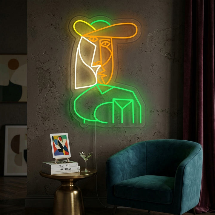 Stylized portrait based on Pablo Picasso's Bust of Woman rendered in glowing yellow and white neon tubing on a textured wall in a modern living room