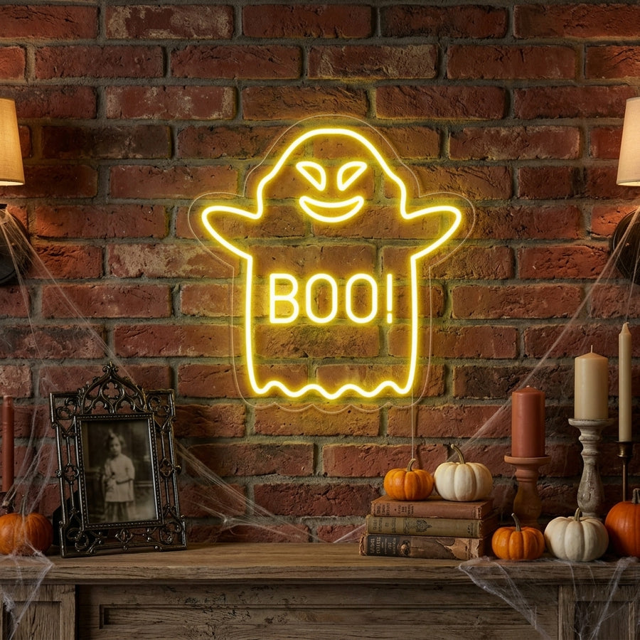 A lifestyle photo of a lit white 'Soaring Boo Ghost' neon sign hanging above a rustic wooden shelf with pumpkins and candles.