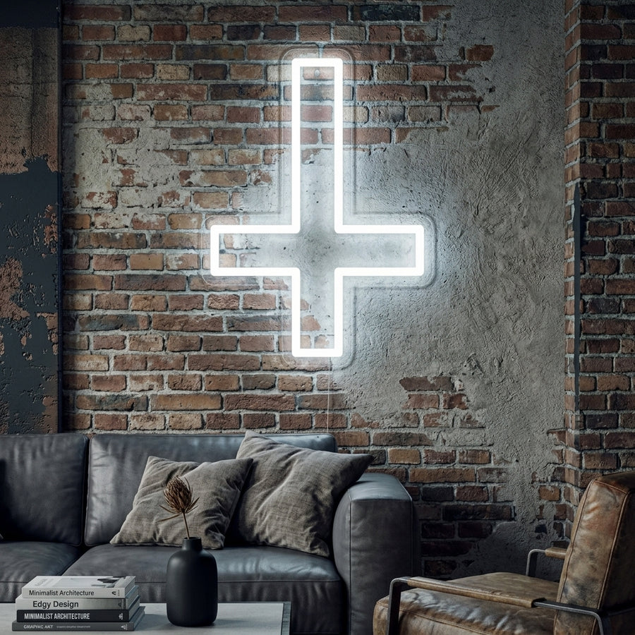 Illuminated Saint Peter inverted Christian cross neon sign on a stone wall in a modern living space