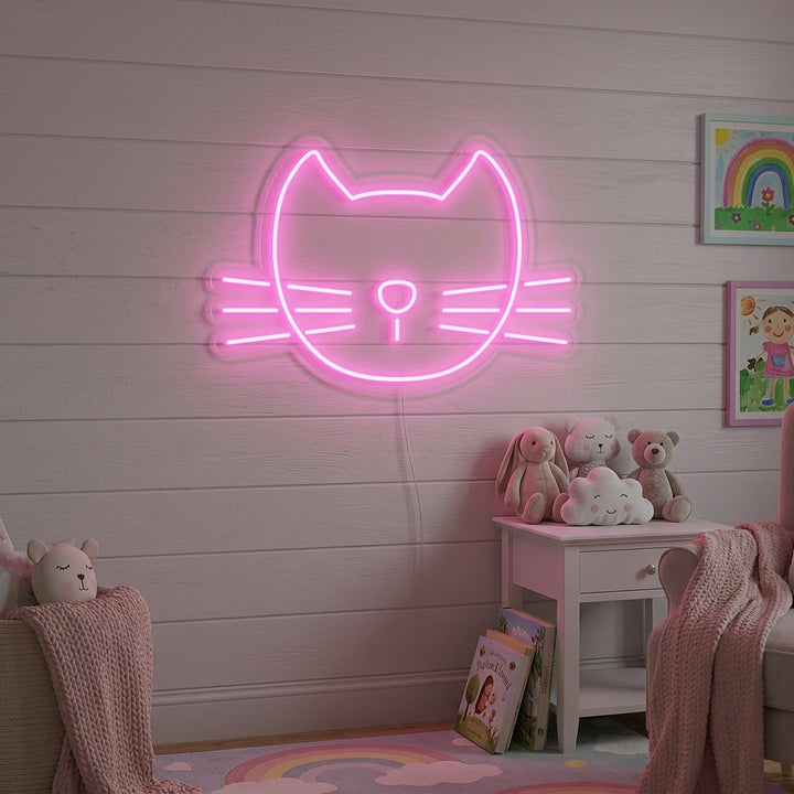 A cozy bedroom corner featuring a glowing pink neon sign of a cute cat's face above a small shelf, providing warm, ambient light.