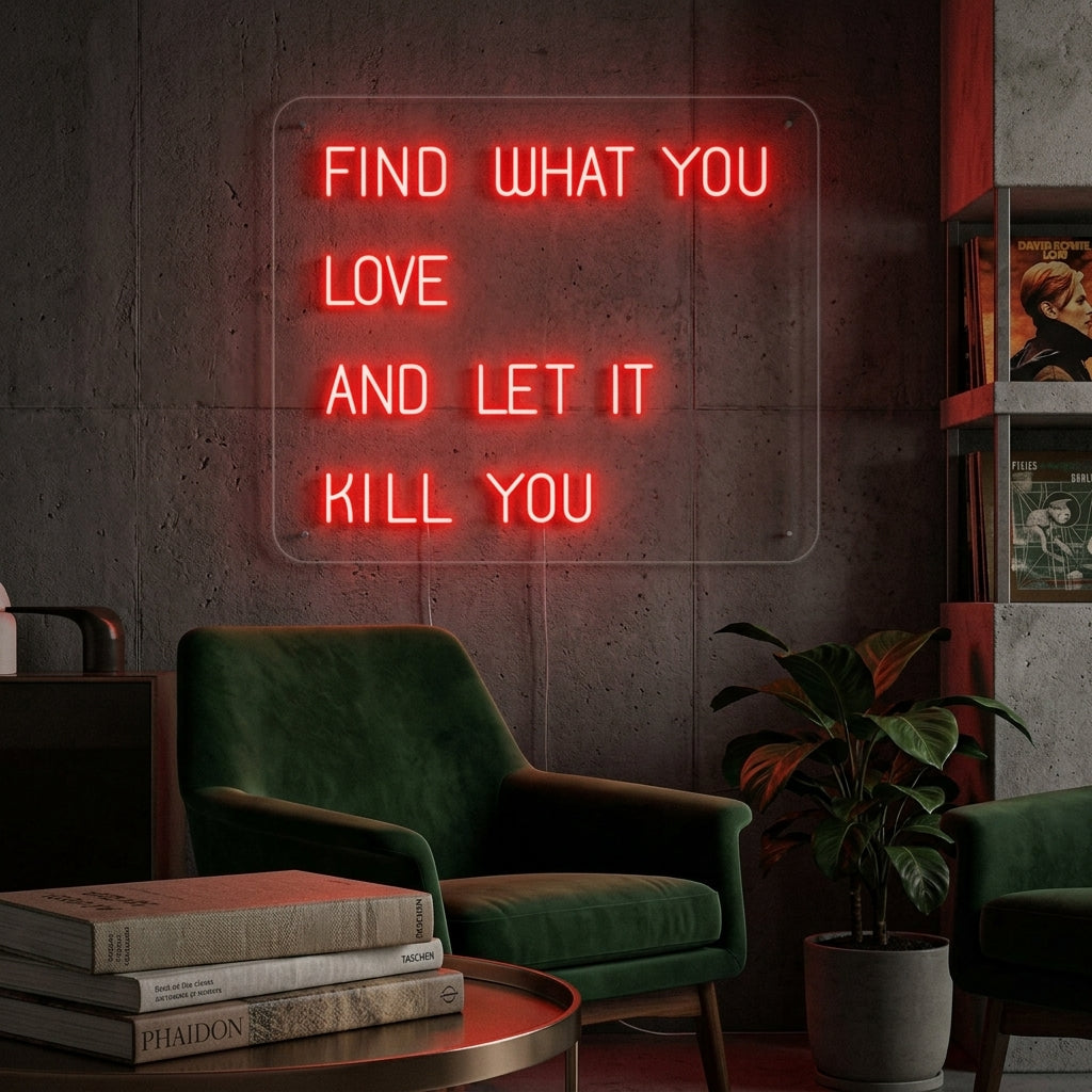 A glowing 'Find What You Love And Let it Kill You' neon sign displayed as wall decor in a modern, plant-filled home office setting above a desk.