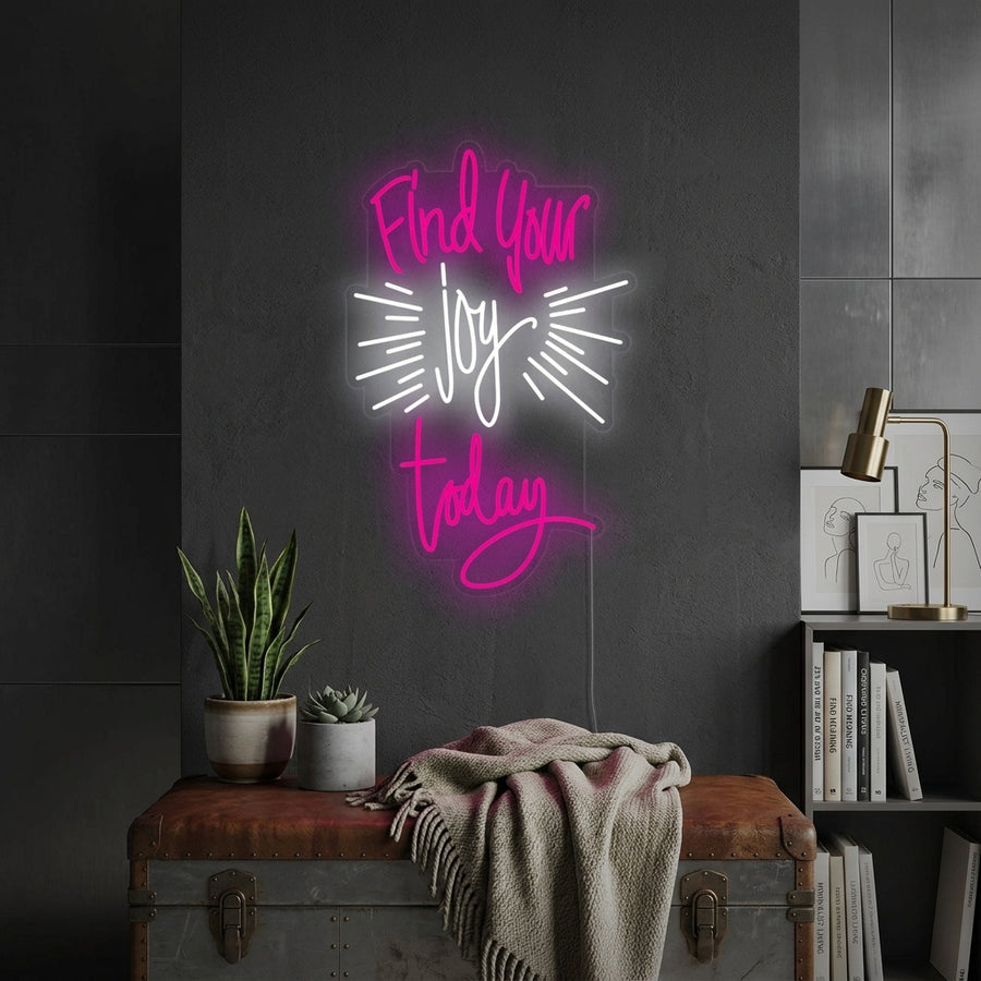'Find Your Joy Today' white script neon sign on a cozy living room shelf with plants and books.