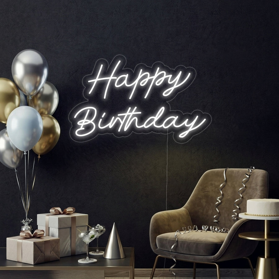 A lifestyle photograph of a 'Happy Birthday' neon sign in use, glowing warmly.