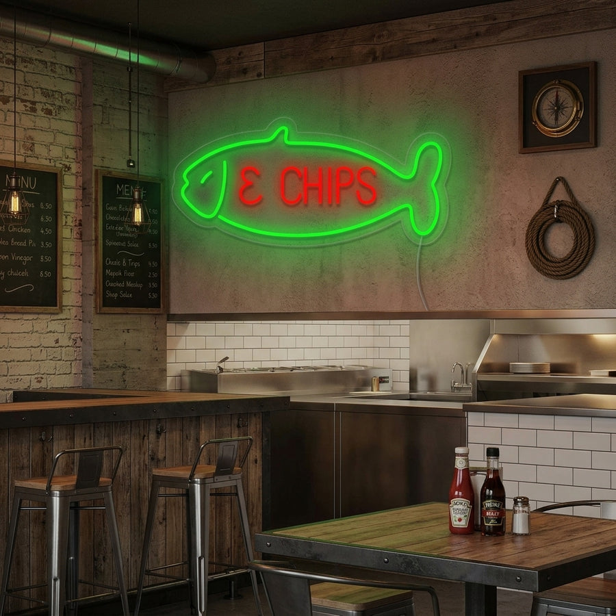 A stylish 'Fish & Chips' neon sign displayed on a wall inside a bustling restaurant setting.