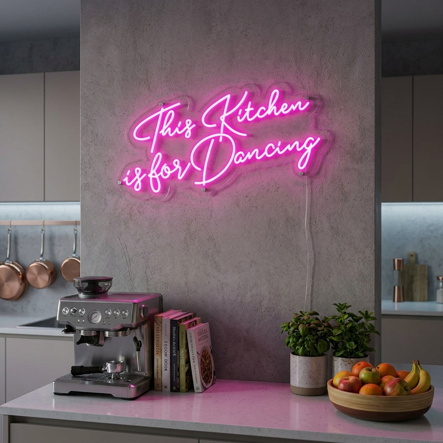 A cozy kitchen with modern cabinets, green plants, and the neon sign 'This Kitchen is for Dancing' glowing above the stove.