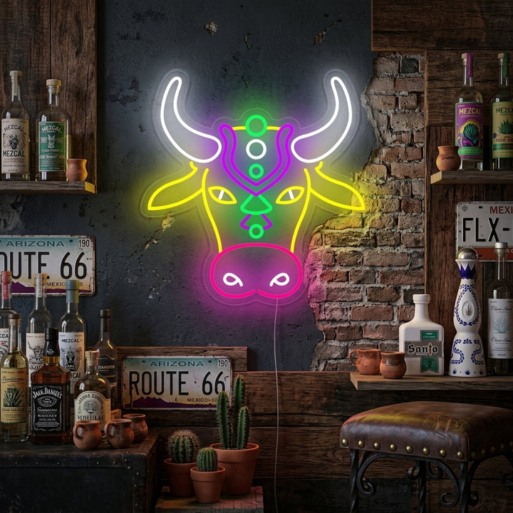 Colorful bull head geometric neon sign glowing with blue, orange, yellow, and purple light mounted on a dark textured wall in a modern living room