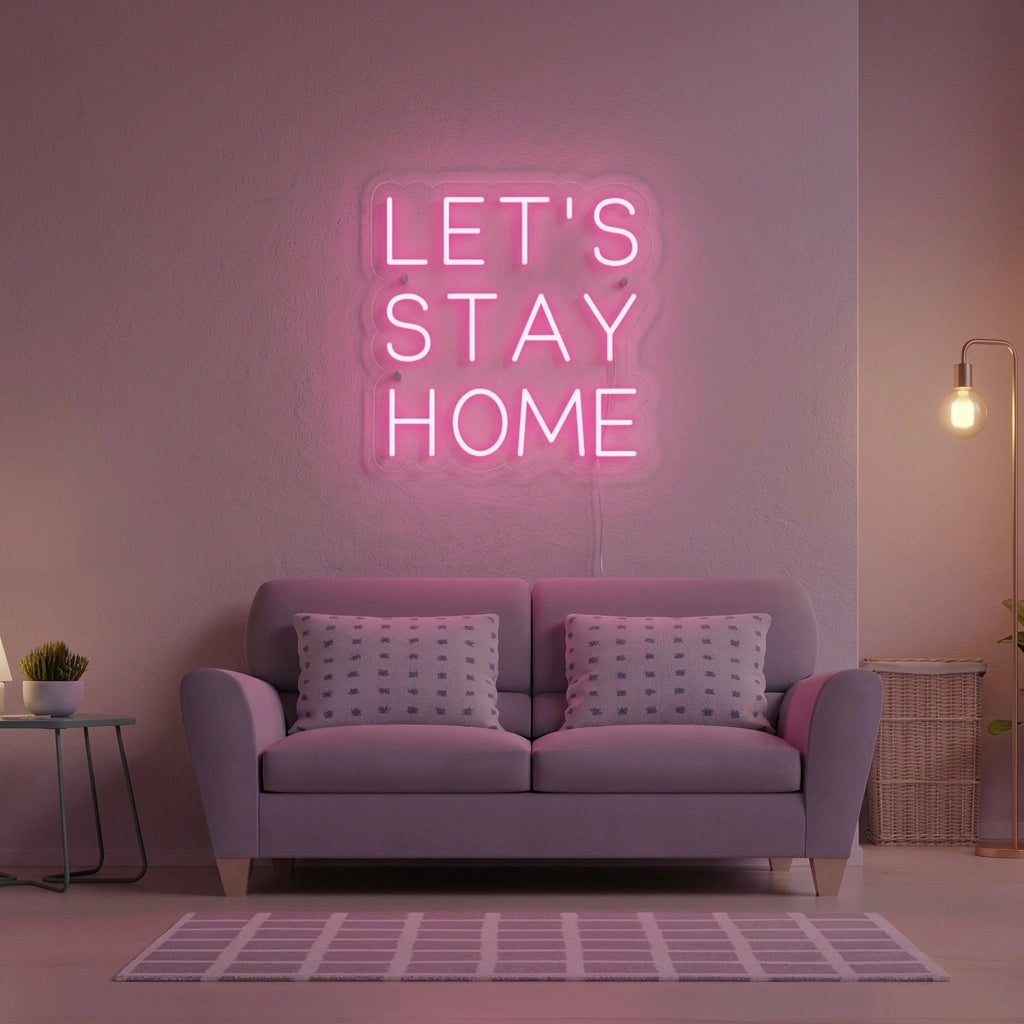 Lets Stay Home neon sign glowing warmly above a sofa in a modern, plant-filled living room