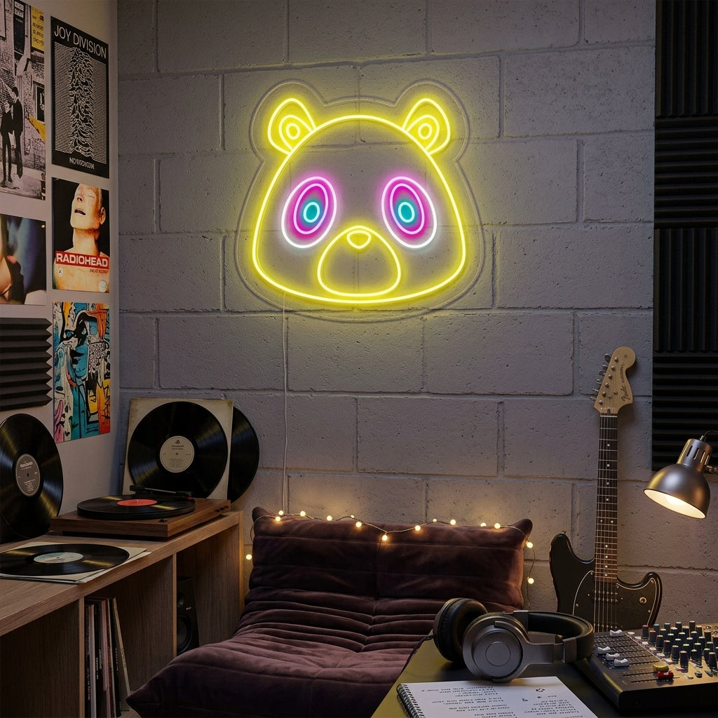 A lifestyle shot showing the vibrant 'Graduation Bear' neon sign illuminating a cozy living room wall above a graduation party decoration setup, featuring a bear wearing a cap and holding a diploma.