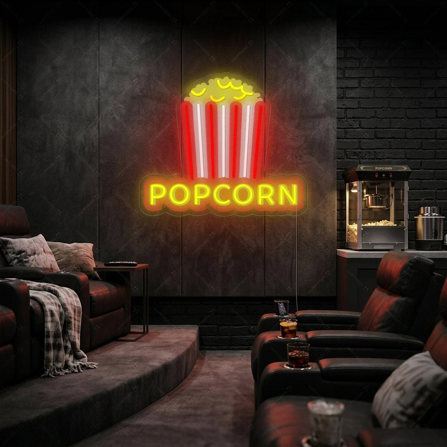 A vibrant glowing neon sign shaped like a red and white striped bucket filled with golden popcorn, casting a warm yellow light.