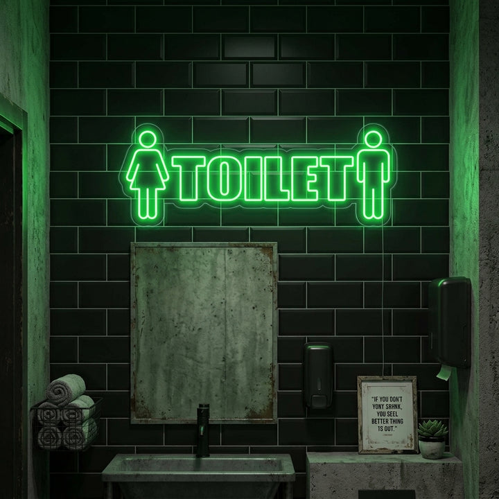 A glowing blue 'Toilet Man Woman' neon sign featuring classic restroom symbols on a rustic wooden wall above a small wash basin in a modern commercial restroom.
