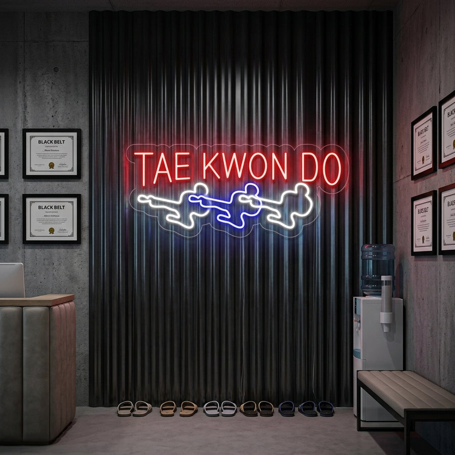Two Taekwondo fighters sparring, depicted in a bright neon wall sign hanging on a textured wall.