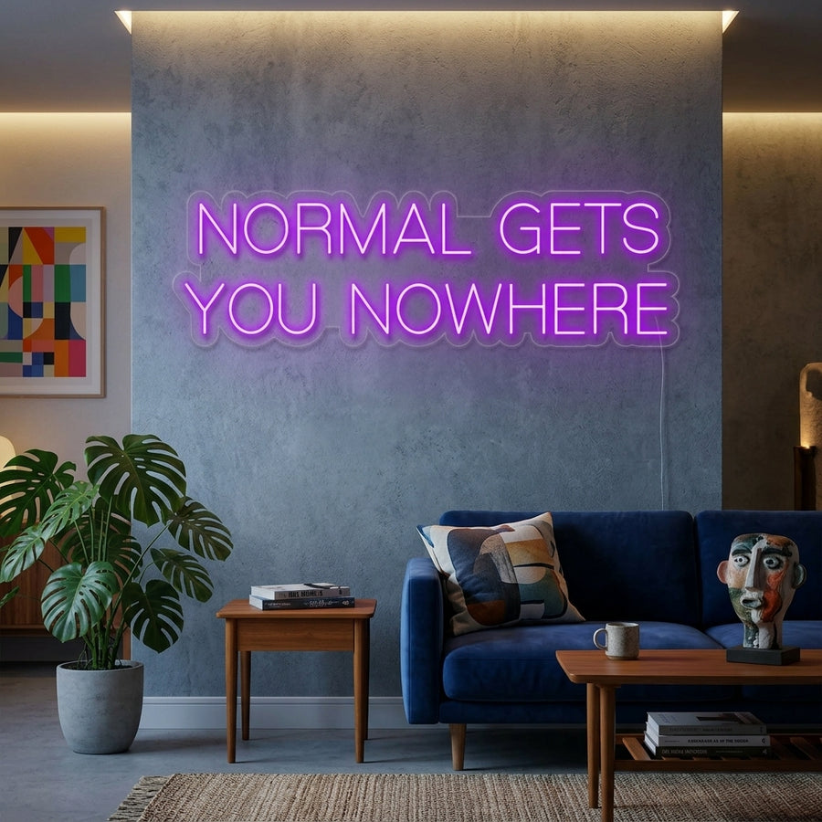A glowing blue 'Normal Gets You Nowhere' script neon sign illuminates a cozy home office, mounted above a wooden desk with plants, books, and a laptop.