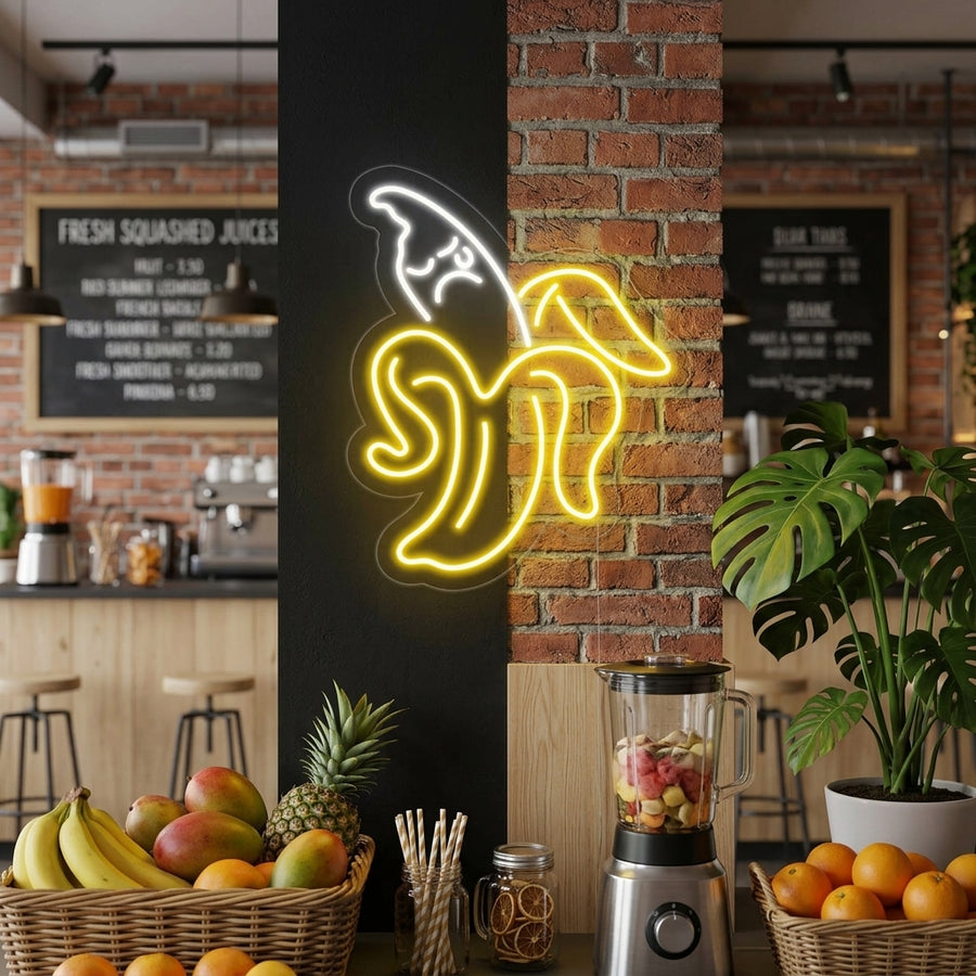 A glowing yellow and green Banana neon sign displayed on a white brick wall above a cozy seating area in a modern cafe.