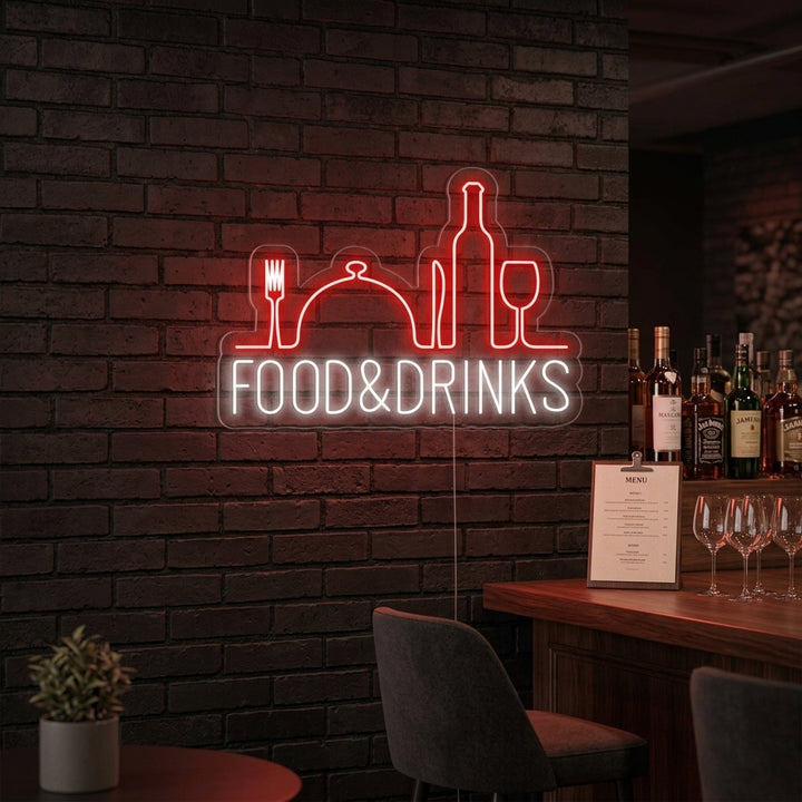 A vibrant 'Food and Drinks Bar Restaurant' neon sign, glowing warmly in an urban setting at night, casting red and blue light on the surrounding wall and reflection.