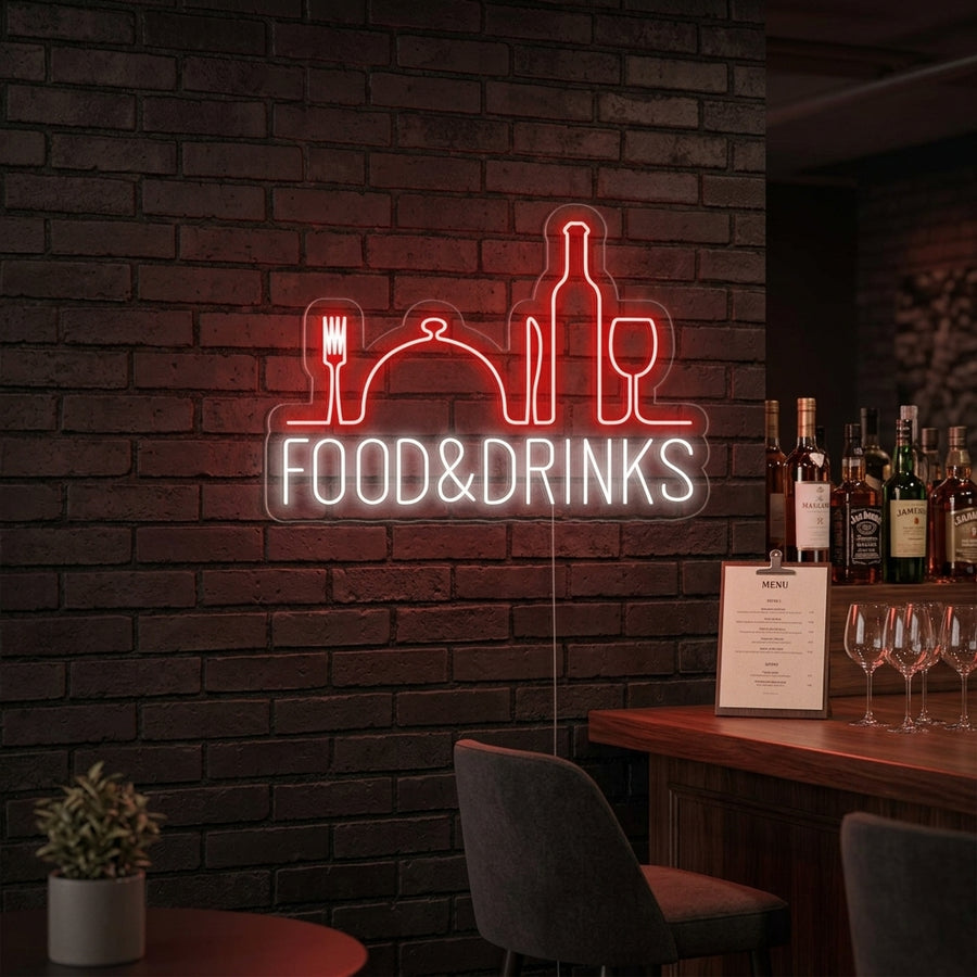 A vibrant 'Food and Drinks Bar Restaurant' neon sign, glowing warmly in an urban setting at night, casting red and blue light on the surrounding wall and reflection.
