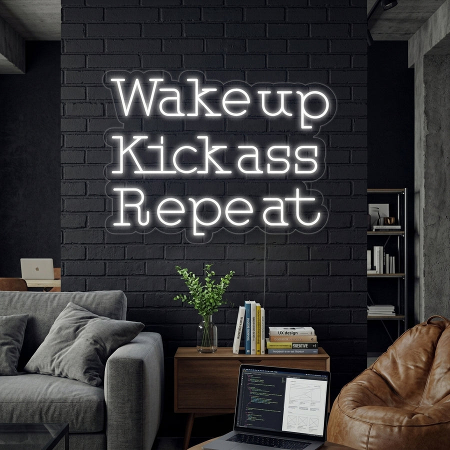 A lifestyle shot showing the glowing 'Wake Up Kick Ass Repeat' neon sign in a positive color mounted above a workout bench and weights in a modern home gym.