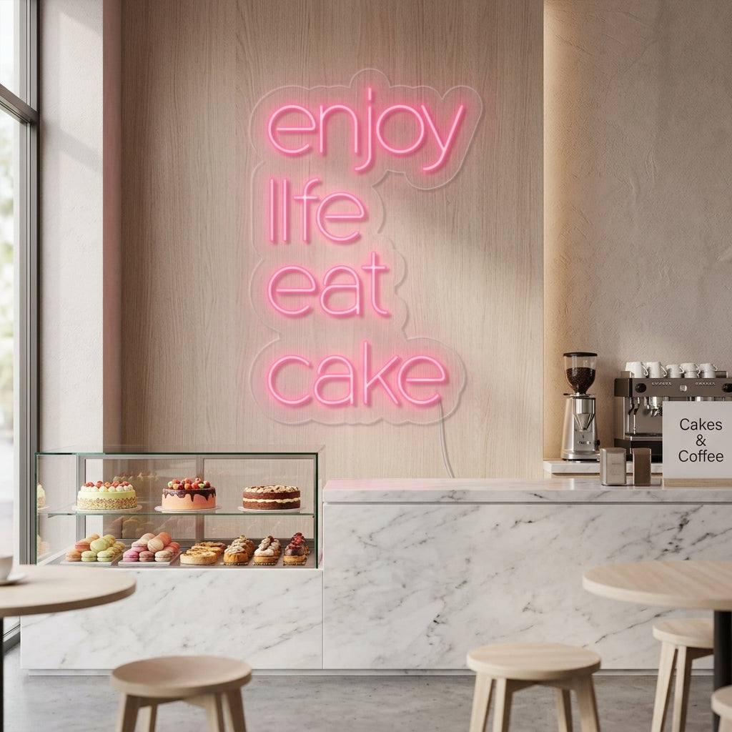 An 'Enjoy Life Eat Cake' neon sign displayed on a wall in a cheerful kitchen setting.