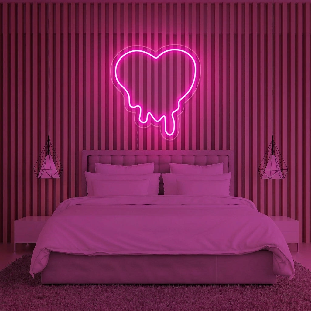 A pink melting heart neon sign casts a warm glow in a bedroom setting