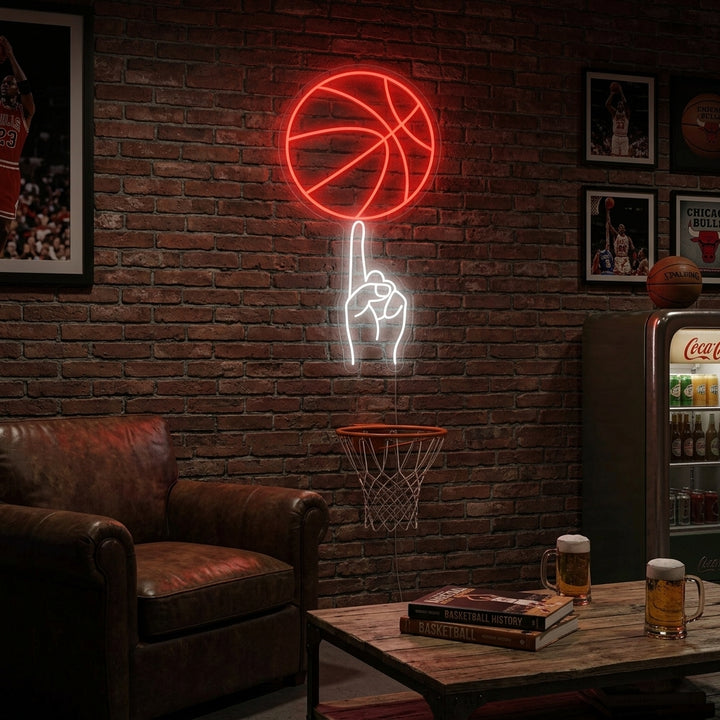 Basketball neon sign glowing orange and white on a brick wall above sports memorabilia and modern furniture in a man cave setting.