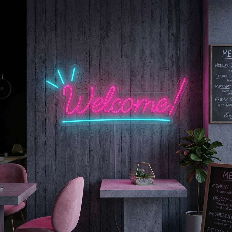 Warm glowing white "Welcome" neon sign in cursive font mounted on a dark textured accent wall above a modern console table with plants.