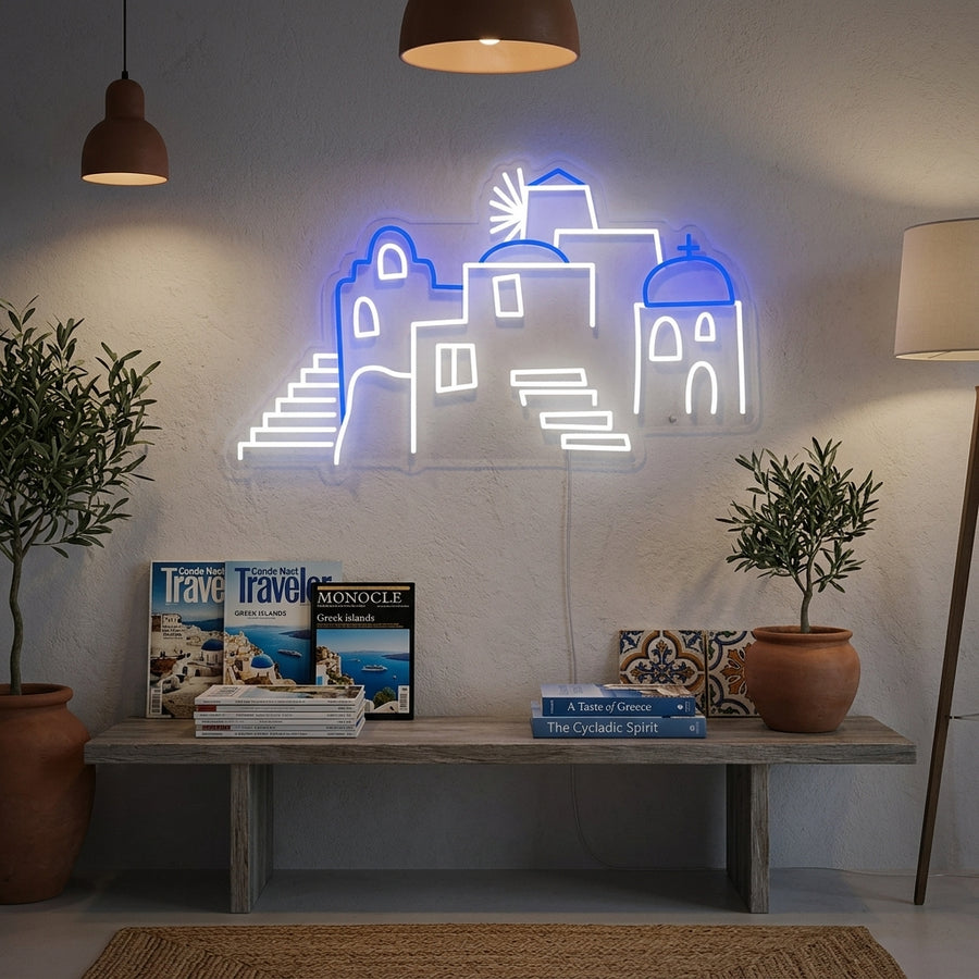 Handmade neon sign depicting the blue domes and white buildings of Santorini, Greece, hanging on a wall in a contemporary living room.