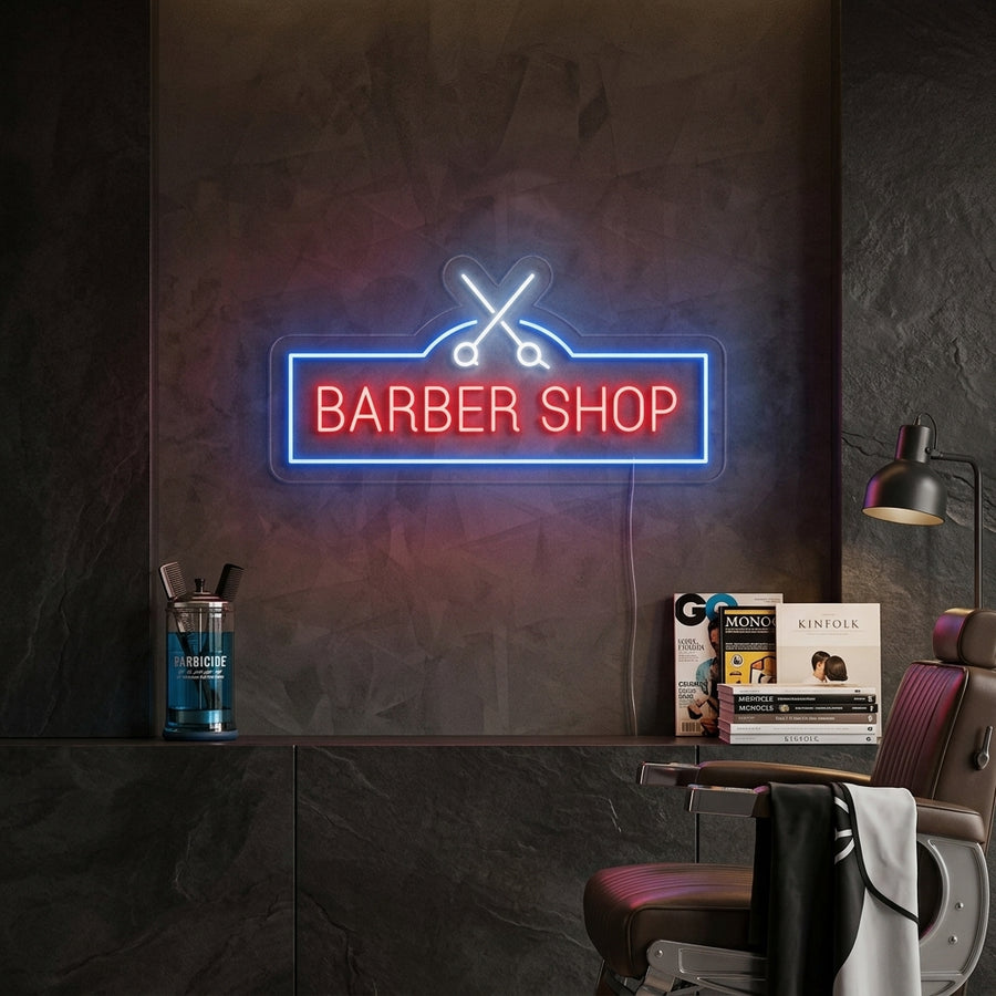 A colorful 'Barber Shop' neon sign with a stylized scissors graphic glowing brightly on a textured wall in a modern barber shop setting.