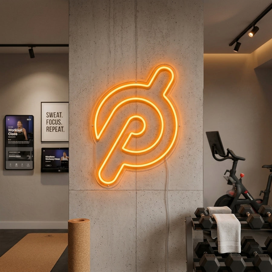 A glowing 'Gym' neon sign illuminated on the wall of a modern home fitness room.