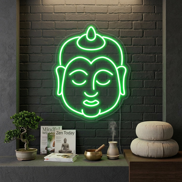 A close-up view of a purple glowing Buddha neon sign hanging on a textured, light gray wall in a yoga or meditation space.
