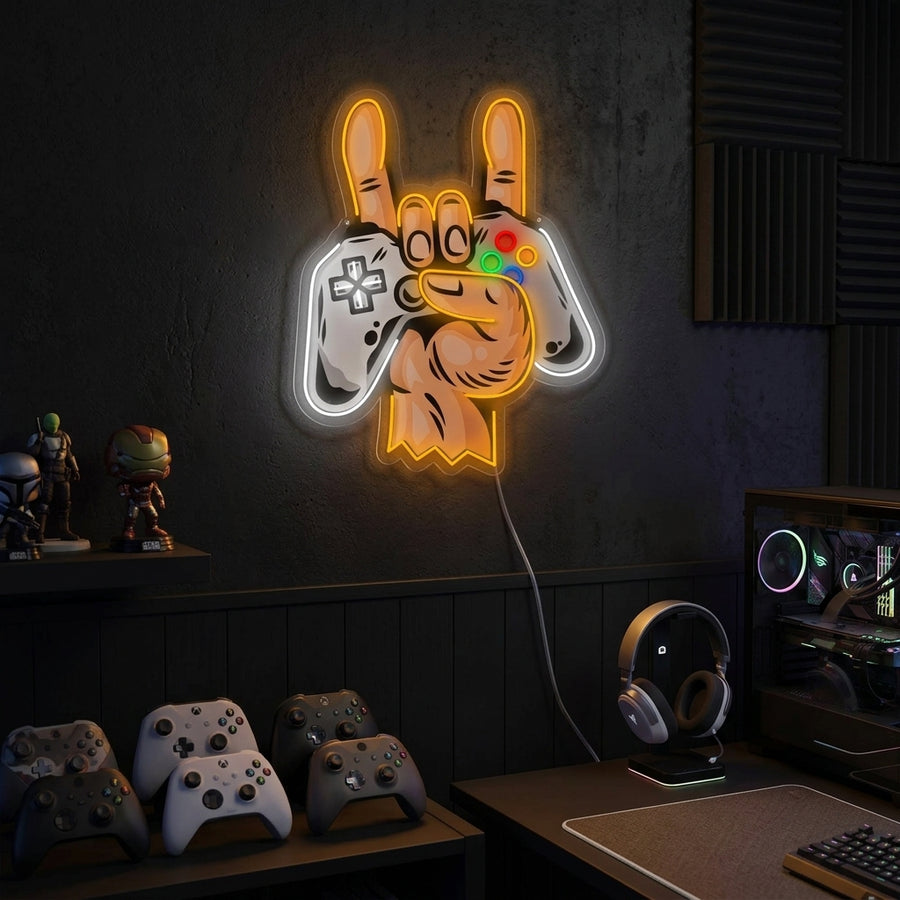 A glowing neon sign featuring a hand holding a game controller mounted on a textured wall in a gaming room