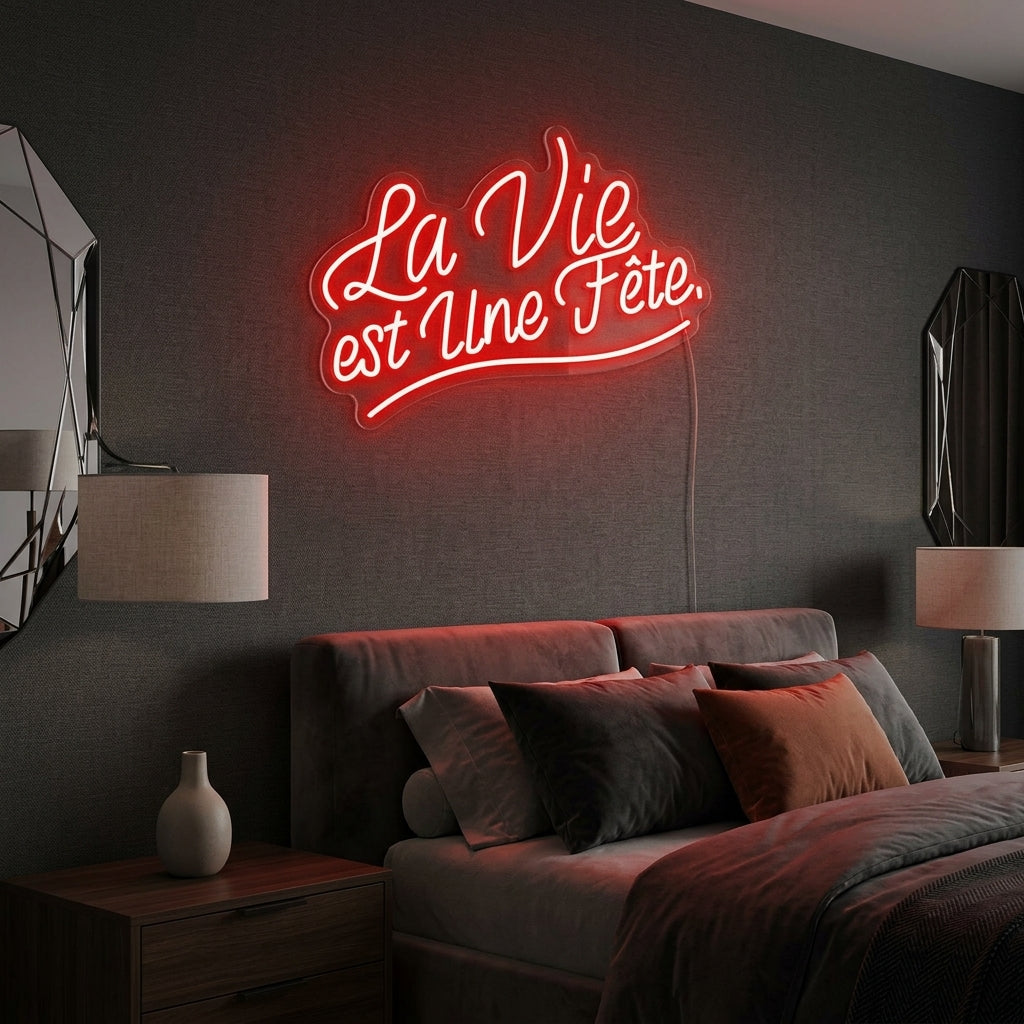 La Vie est Une Fete (Life is a party) glowing neon sign mounted on a textured living room wall above a modern sofa
