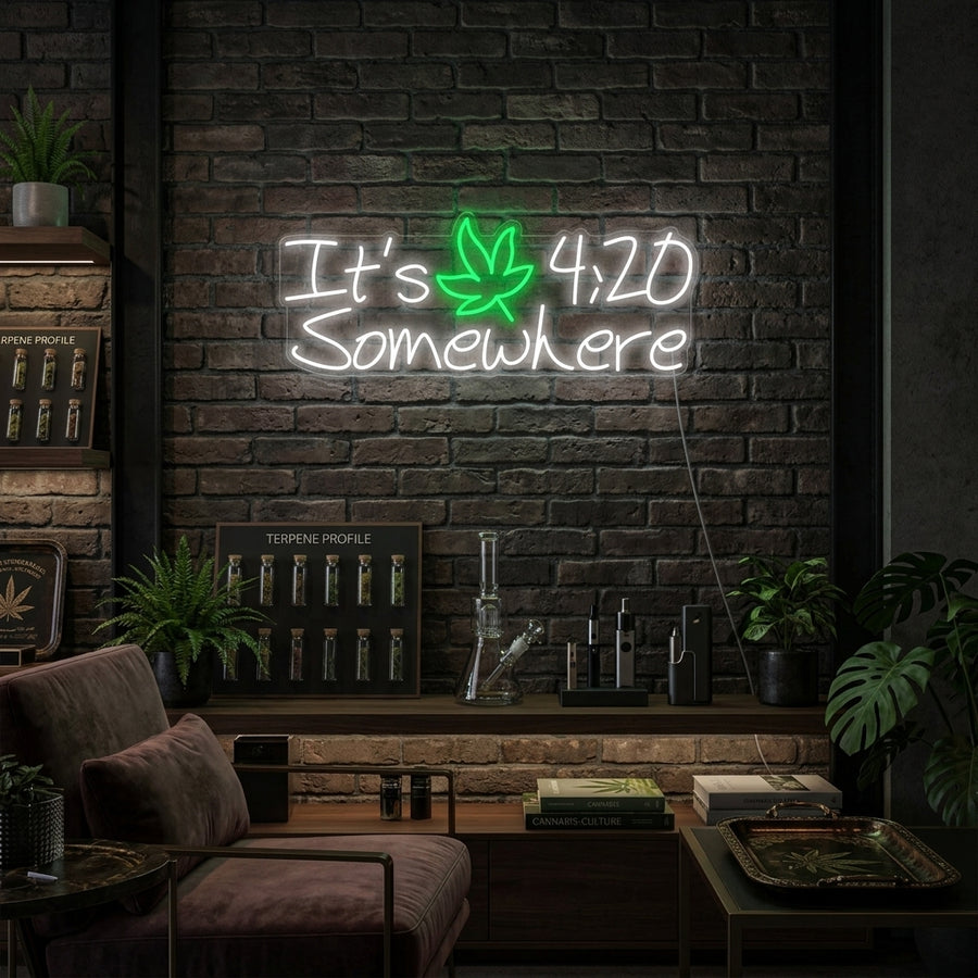 Its 420 Somewhere neon sign in green glowing above a wooden bar cart with decanters and glassware