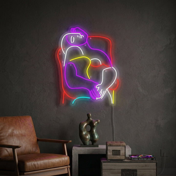 A vibrant 'The Dream Pablo Picasso' neon sign depicting a cubist face with colors glowing in a modern room setting.
