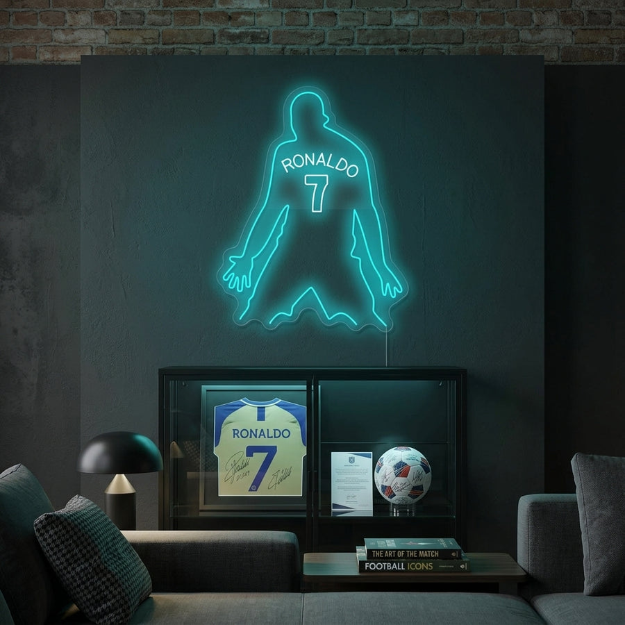 Glow of a neon sign featuring a star and soccer ball mounted on a modern living room wall above a sofa