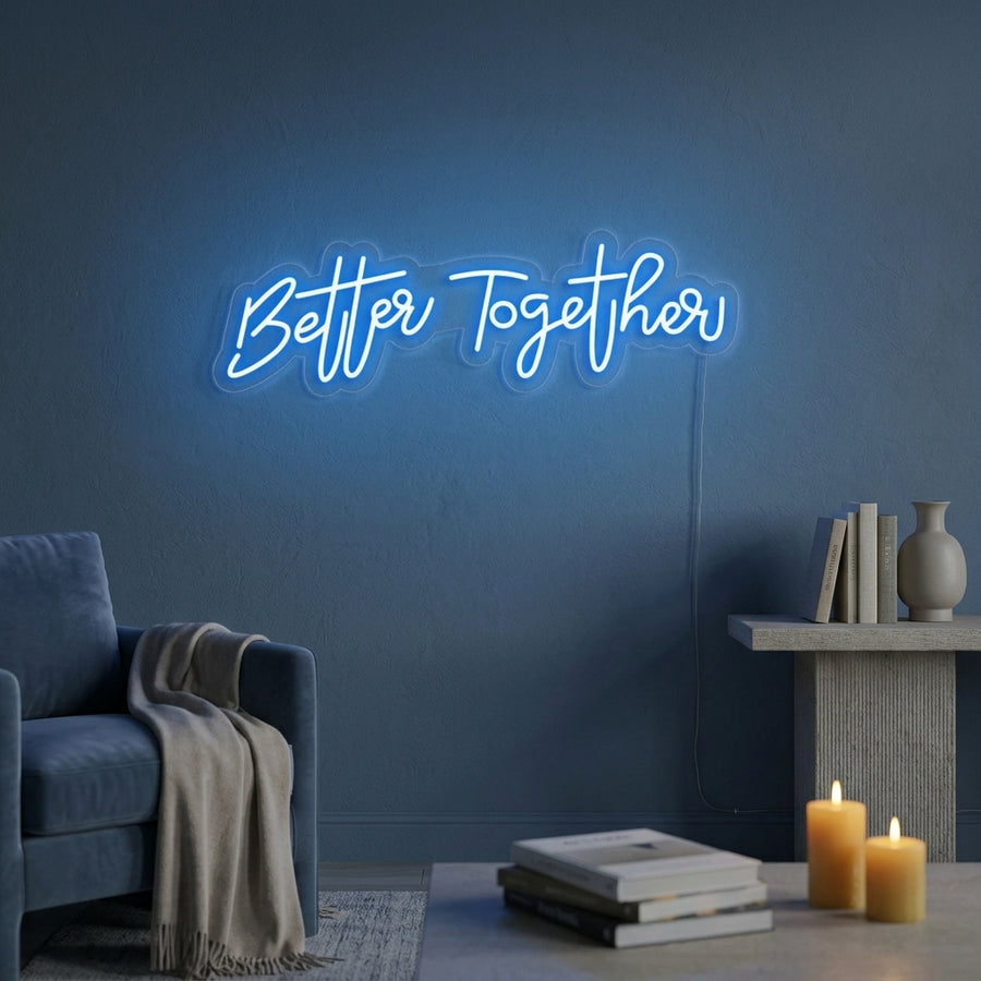 Better Together glowing script neon sign styled in a cozy living room setting above a sofa.