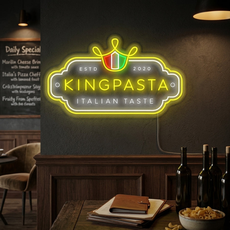 A glowing 'King Pasta' neon sign on a textured wall, featuring yellow light and a crown design above wavy noodles.