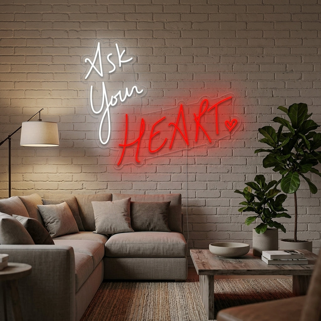 A cozy living room featuring the 'Ask Your Heart' neon sign glowing softly on the wall above a textured sofa and plants.