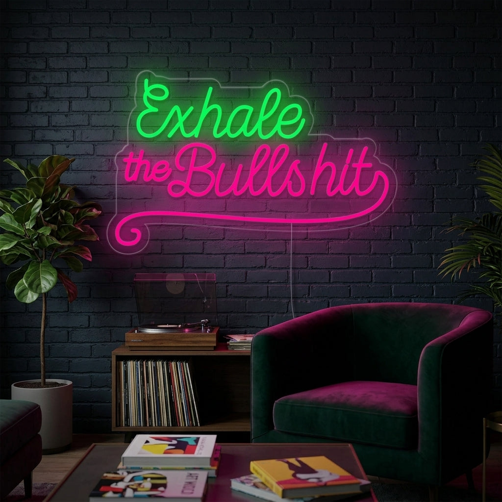 A candid, well-lit photograph showing the 'Exhale The Bullshit' neon sign mounted in a living room, glowing brightly in white text.