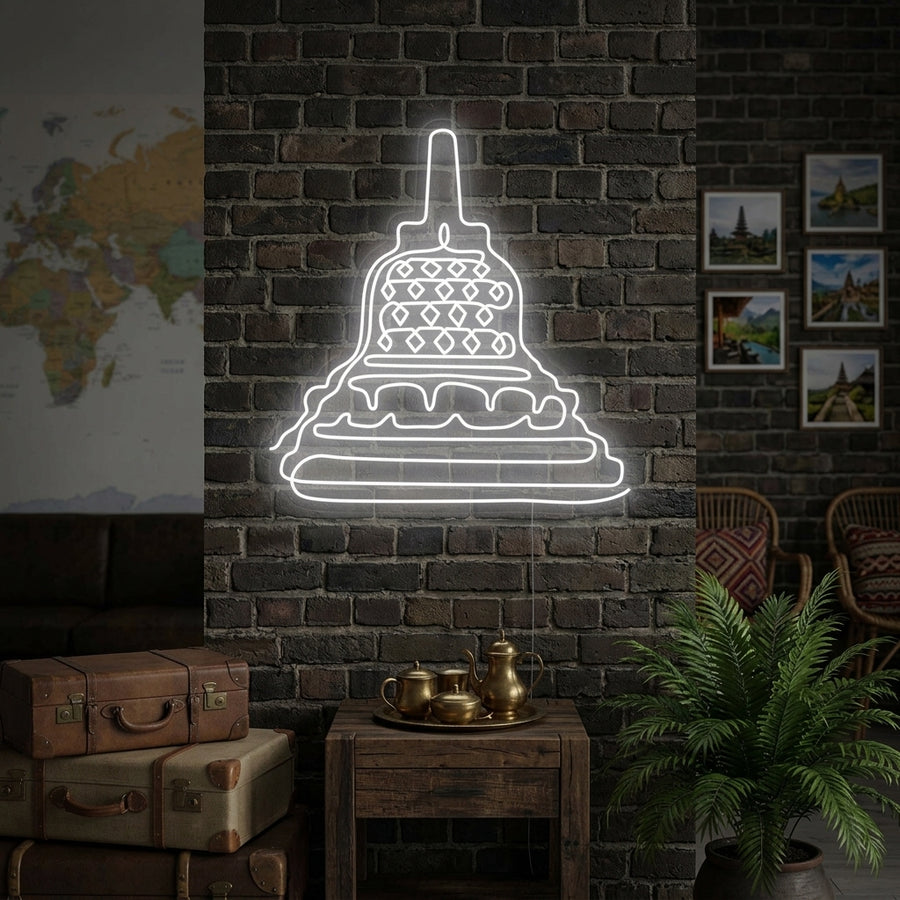 A glowing neon sign depicting the intricate tiers and stupas of the Borobudur Temple mounted on a wall in a contemporary living room setting.