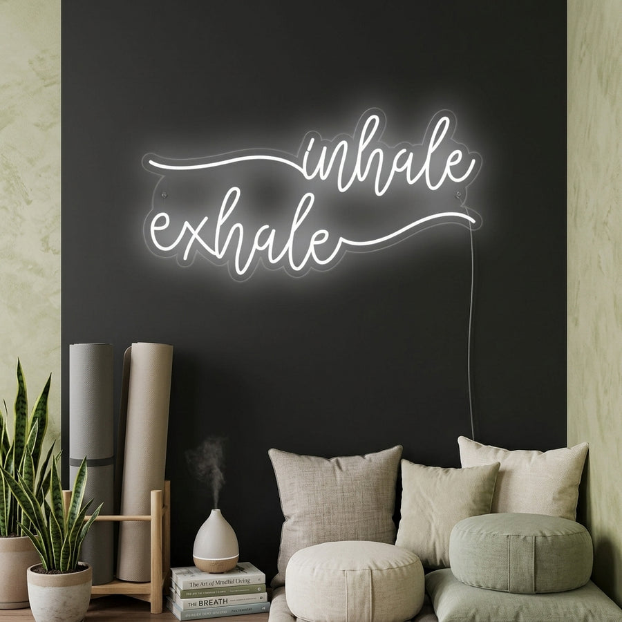 Inhale Exhale glowing text neon sign mounted on a textured wall in a relaxation room setting