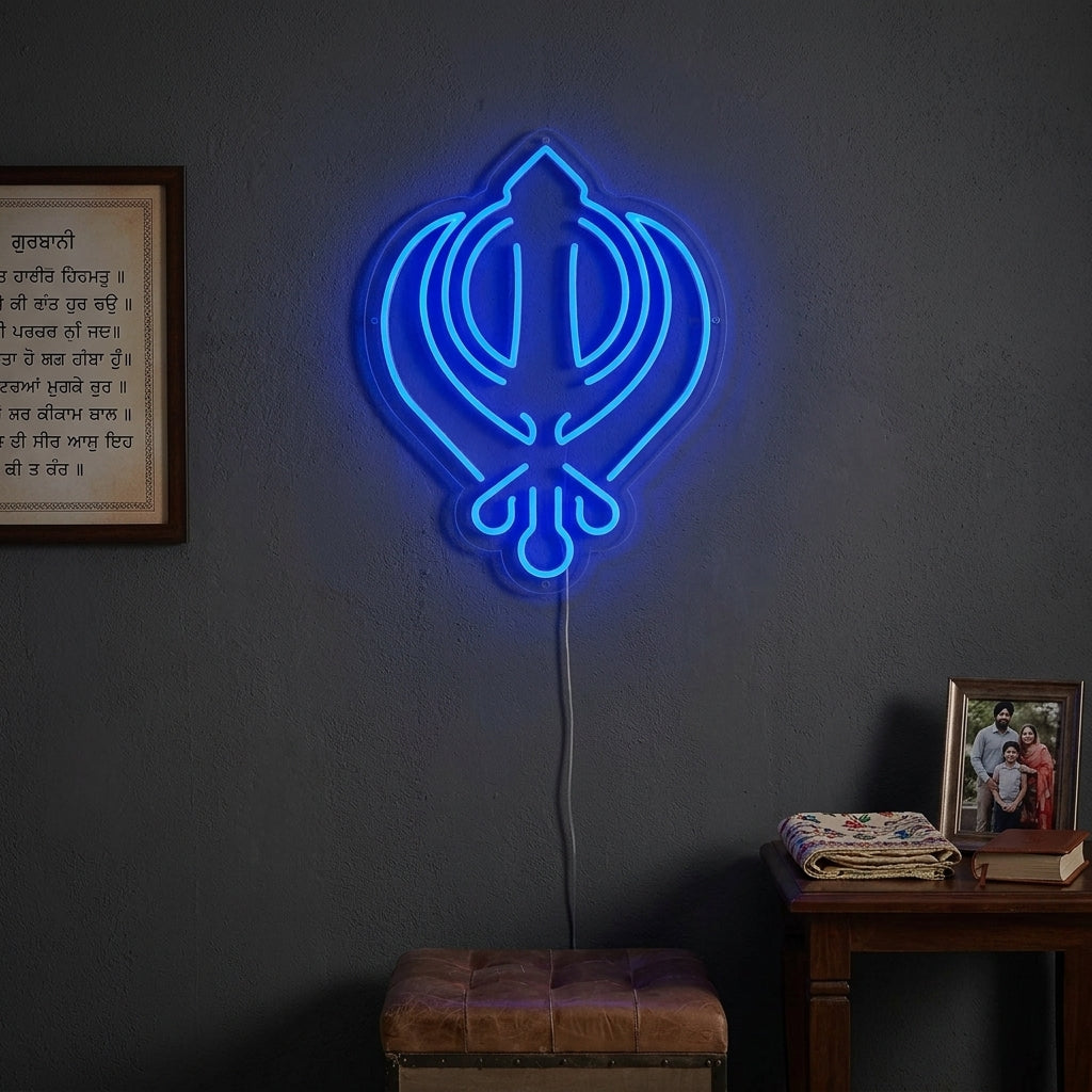 A illuminated 'Sikhism Khanda Symbol' neon sign displayed prominently on a modern living room wall above a sofa, casting a blue glow.