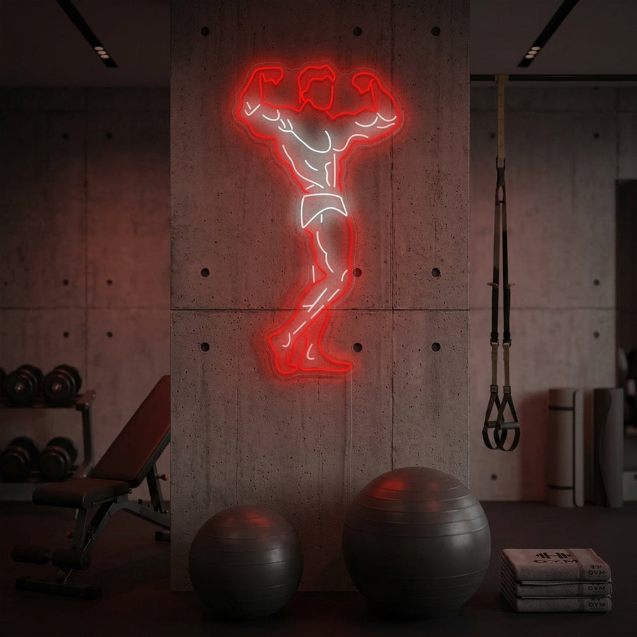 A vibrant 'Gym Hero' neon sign with an energetic glow mounted on a dark wall above workout equipment in a home gym setting.