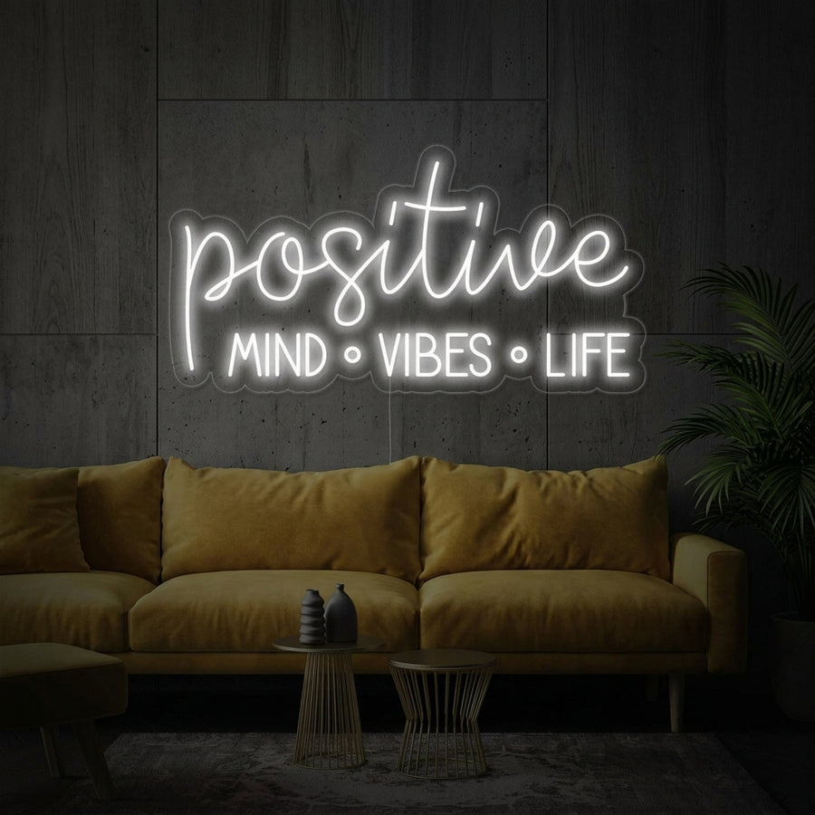 Positive Mind Vibes Life glowing neon wall sign styled in a modern living space.