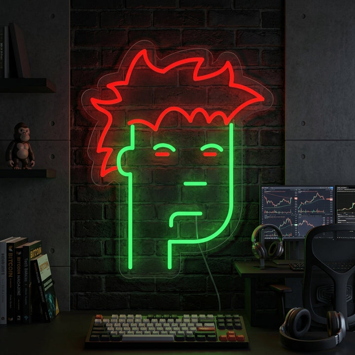 A glowing blue NFT Monkey neon sign displayed prominently above a dark wooden desk in a modern office setup with plants.