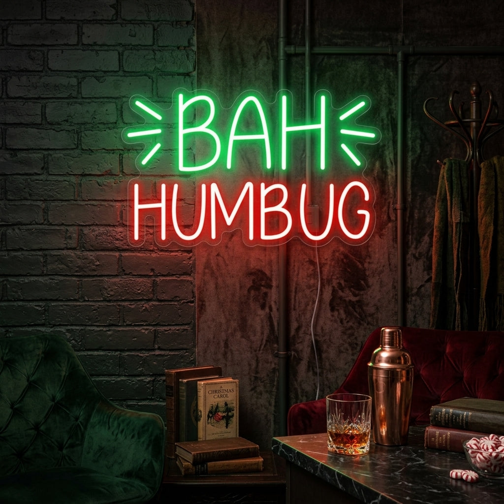 A glowing 'Bah Humbug' neon sign in cursive script mounted on a dark brick wall above a cozy armchair with a festive plaid blanket.