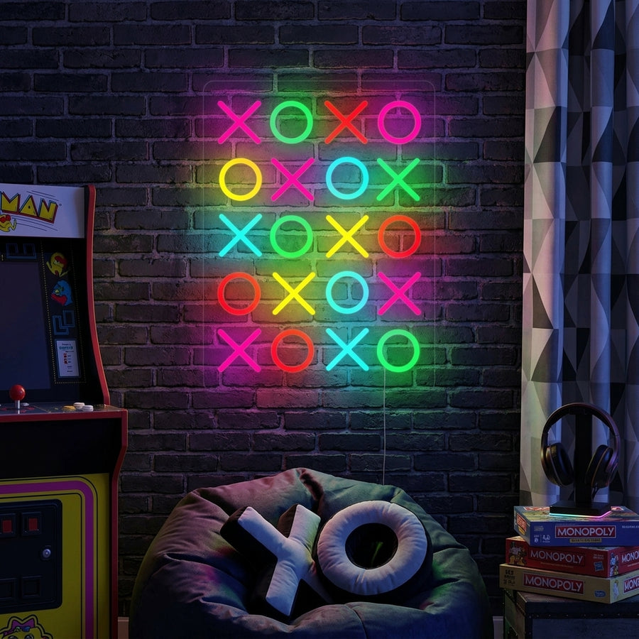 Warm glow from 'Love You Lots XOXO' neon sign illuminating a cozy living room, mounted above a small sofa with textured pillows and house plants.