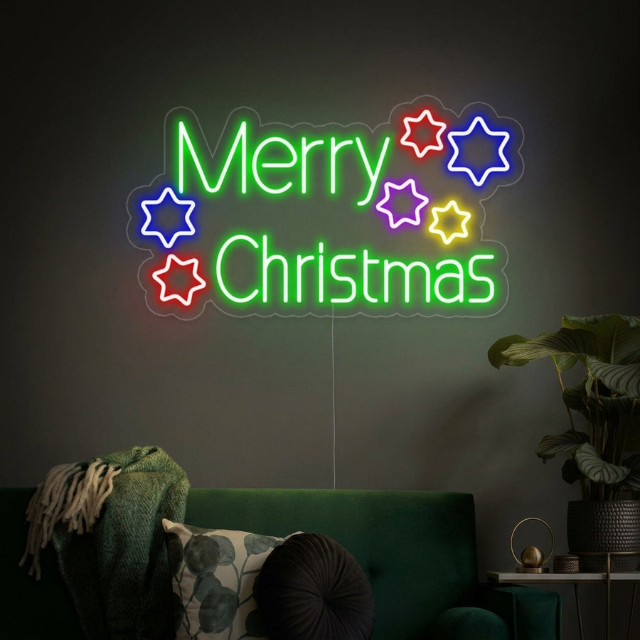 A glowing 'Merry Christmas Stars' neon sign displayed as festive wall decor in a beautifully decorated cozy living room.