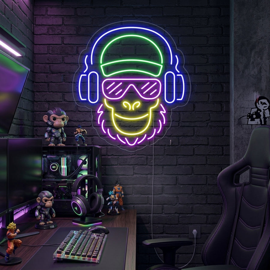 Close-up of the lit 'Cool Monkey' neon sign, featuring a chimpanzee wearing sunglasses, on a living room wall with a plant.