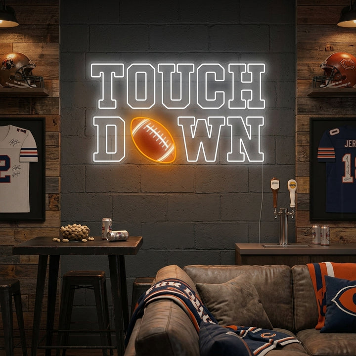 A 'Touchdown' American football neon sign glowing brightly on a brick wall in a rustic game room or bar setting.