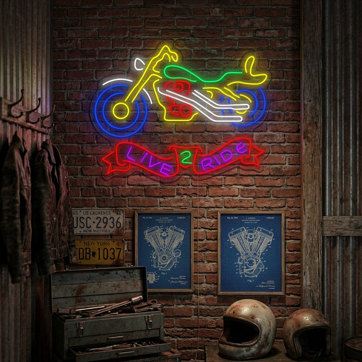 A glowing blue 'Live 2 Ride' neon sign mounted on a dark brick wall above a vintage motorcycle in a well-styled garage setting.